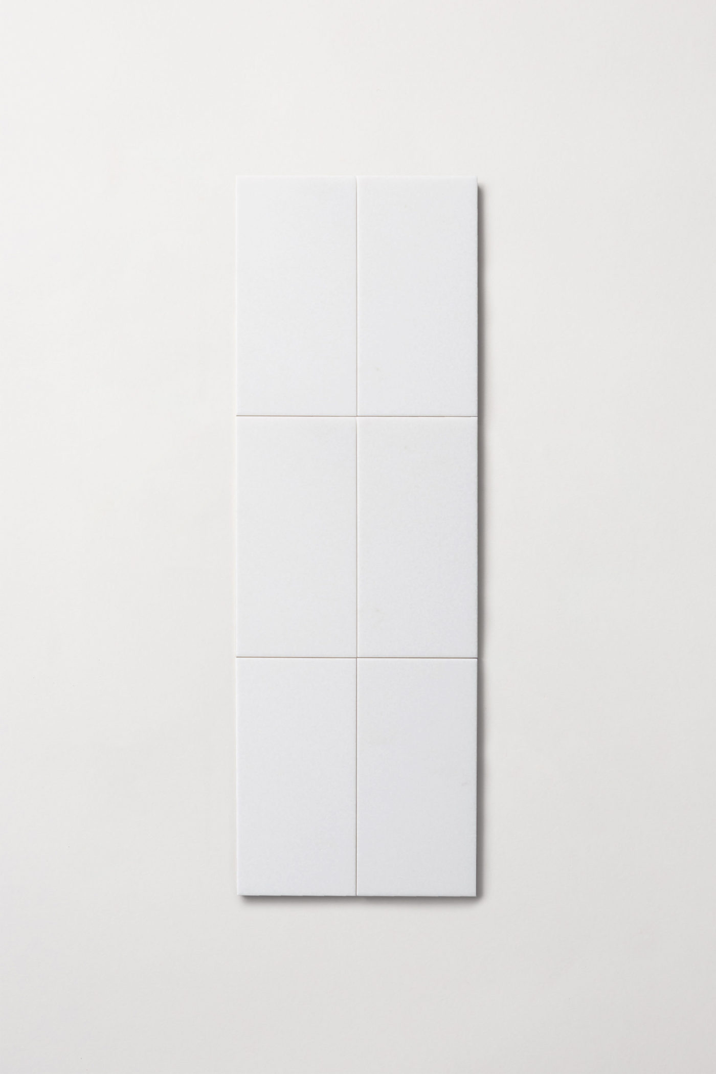 three white square tiles on a white surface.