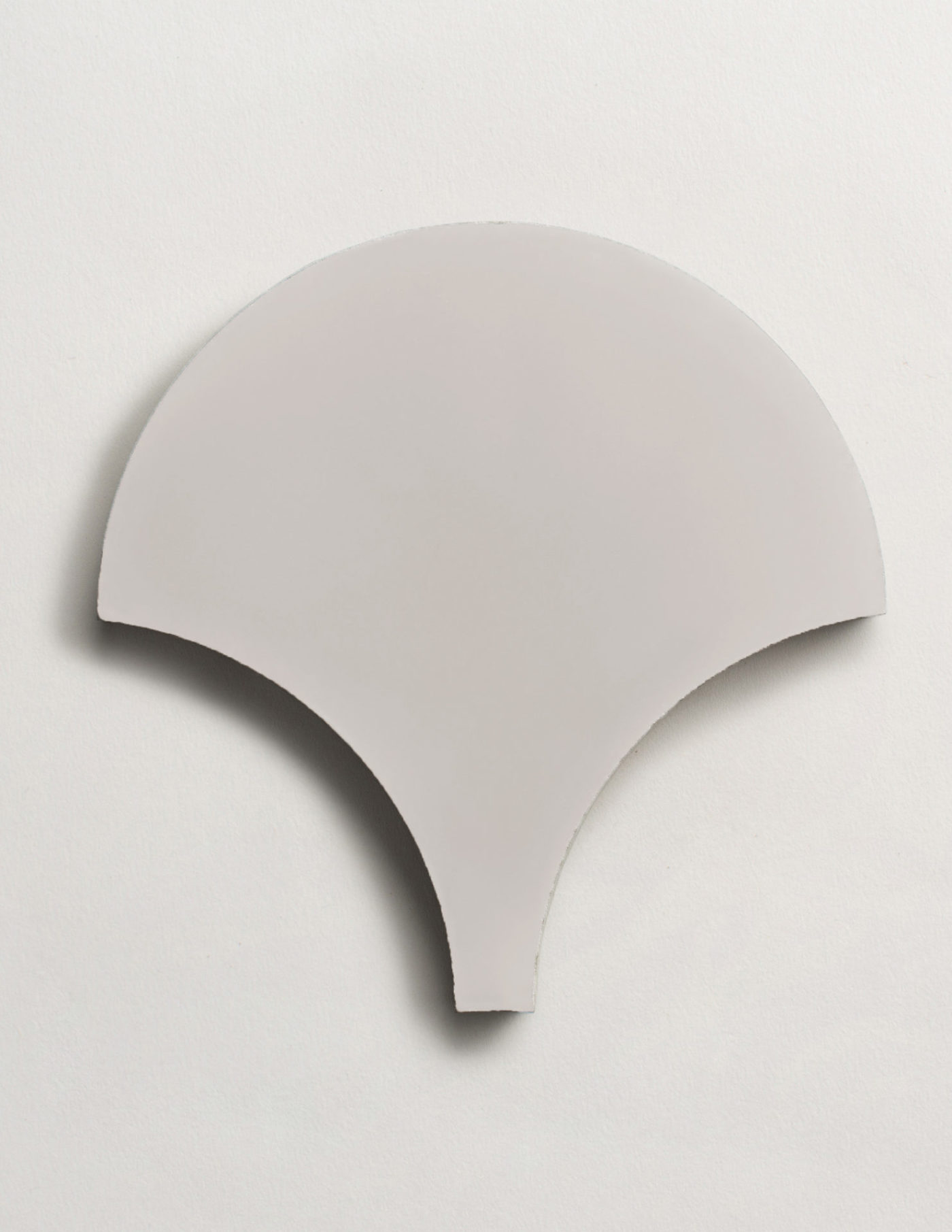 a grey scallop-shaped tile on a white background.