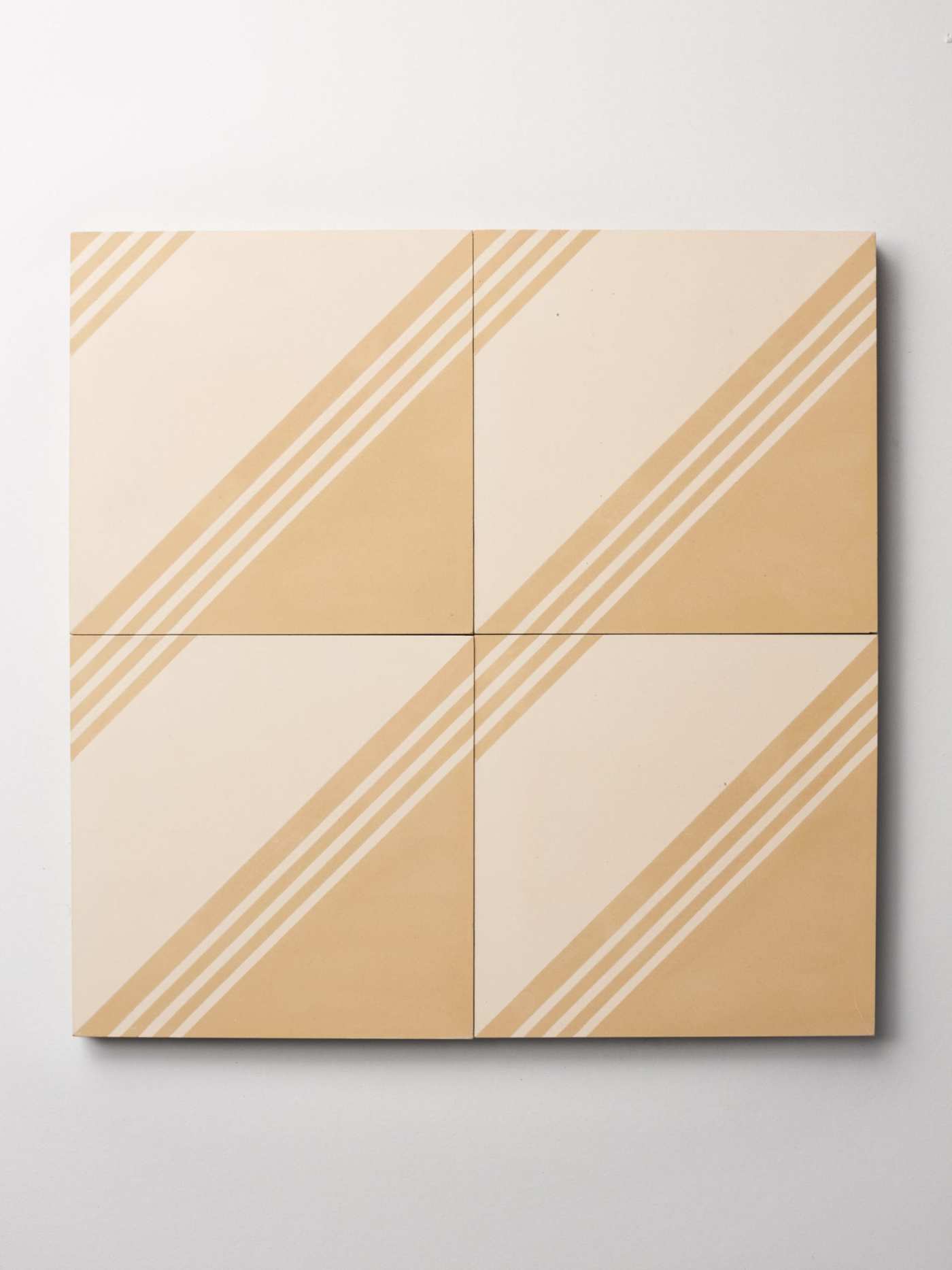 four white and beige tiles with stripes on them.