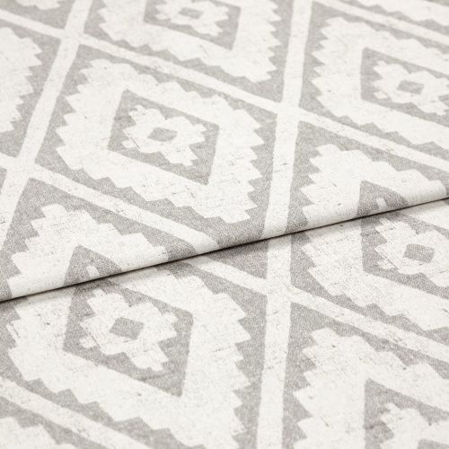Woven rug with repeating gray diamond-and-zigzag pattern, shown folded once across the center; textured fabric lies flat in soft, even studio lighting, close-up detail view.