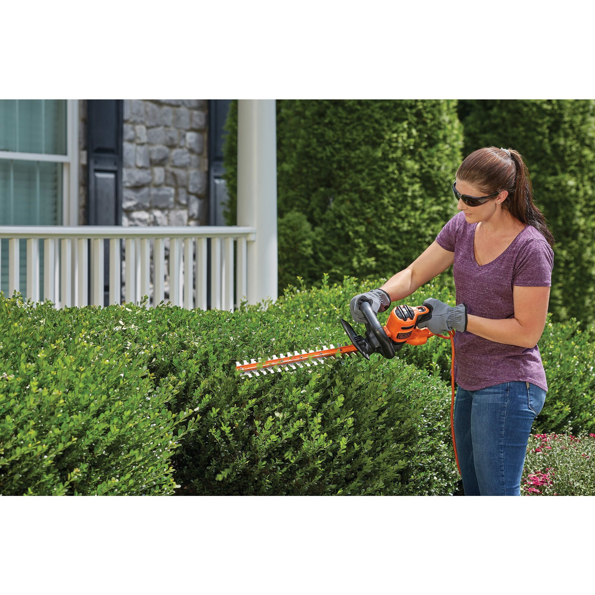 22 inch Electric Hedge Trimmer being used by person to trim bushes.