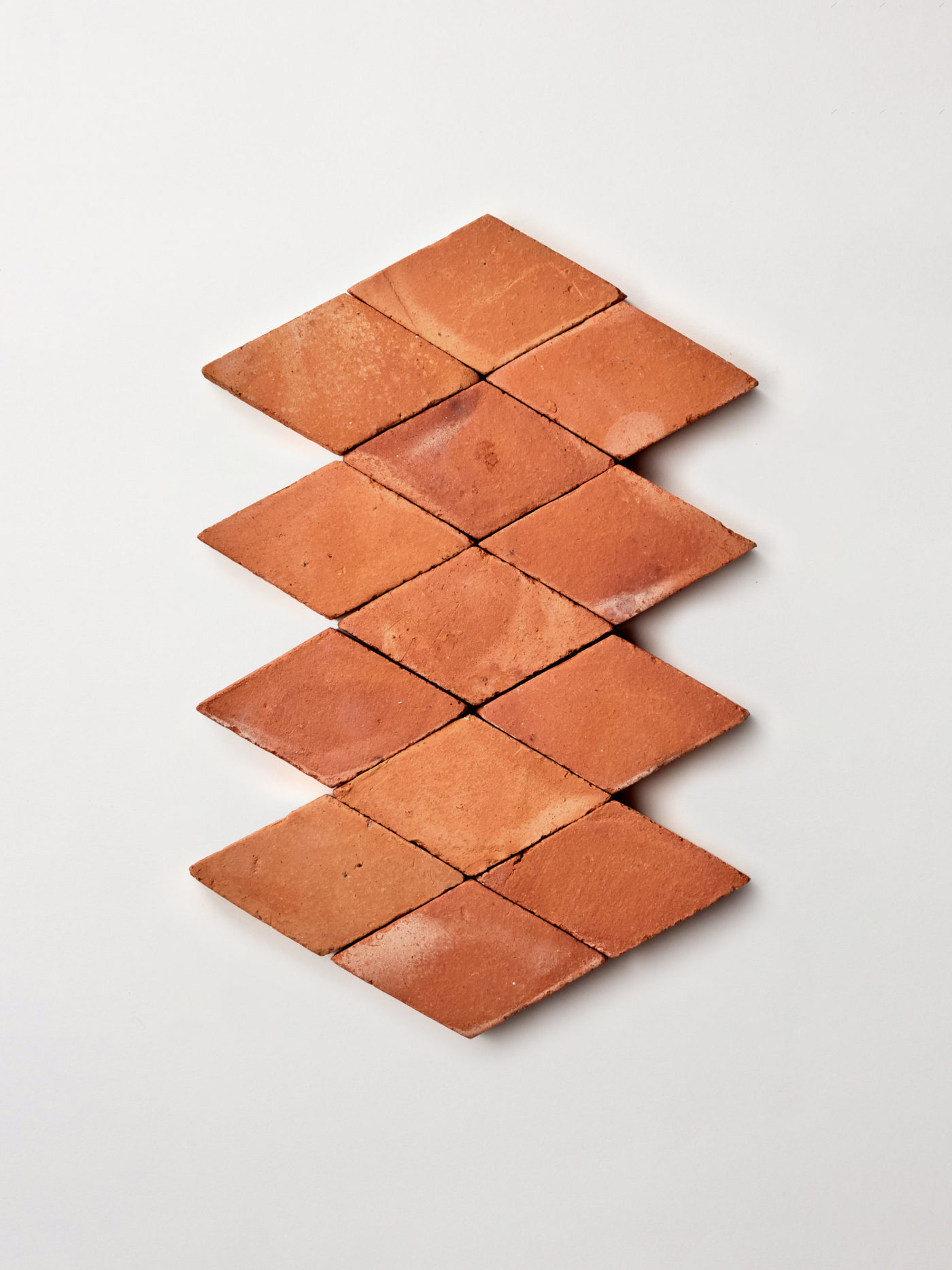 a group of red diamond terracotta tiles on a white background.