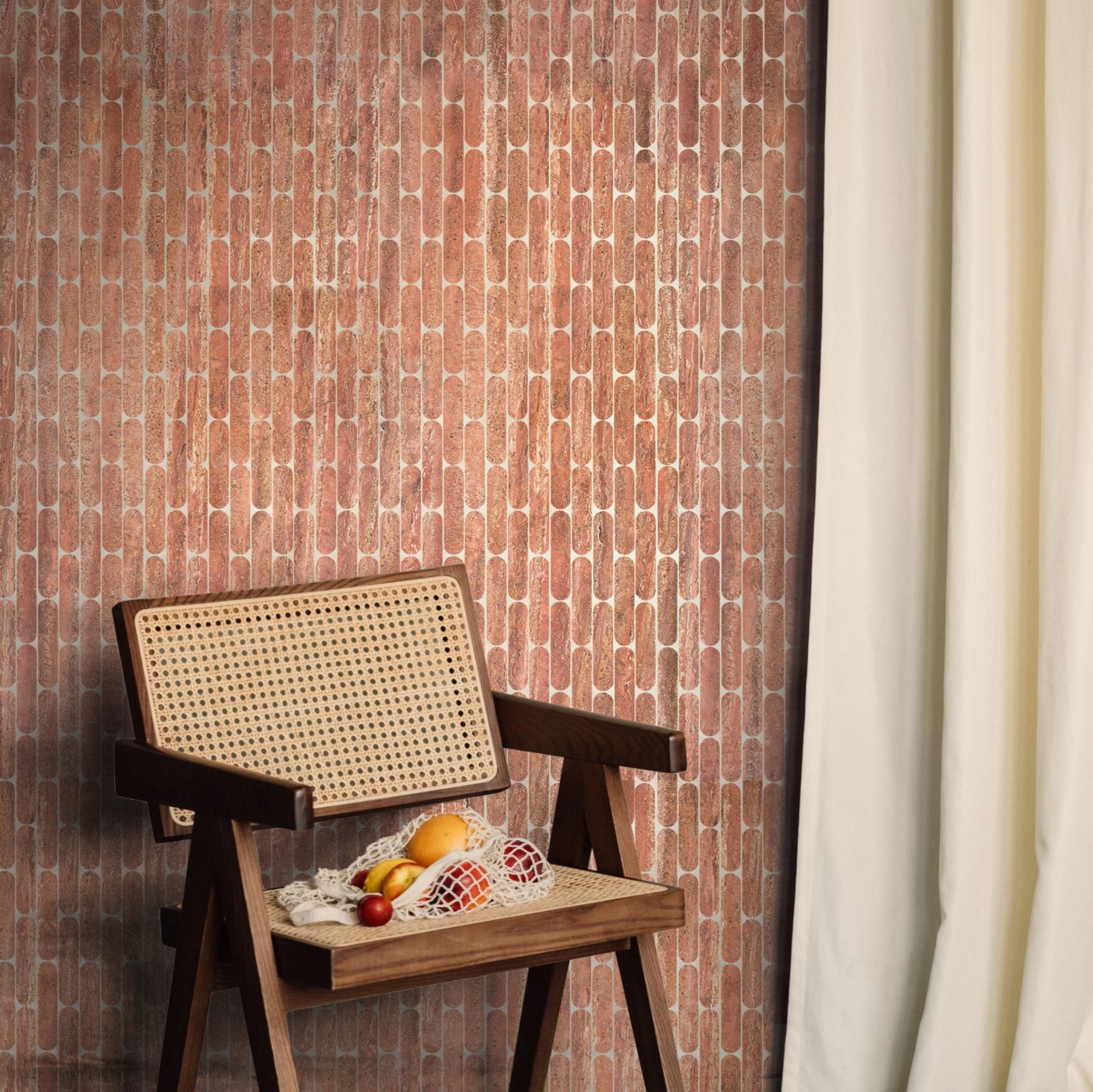 a rattan chair in front of a red tiled wall.