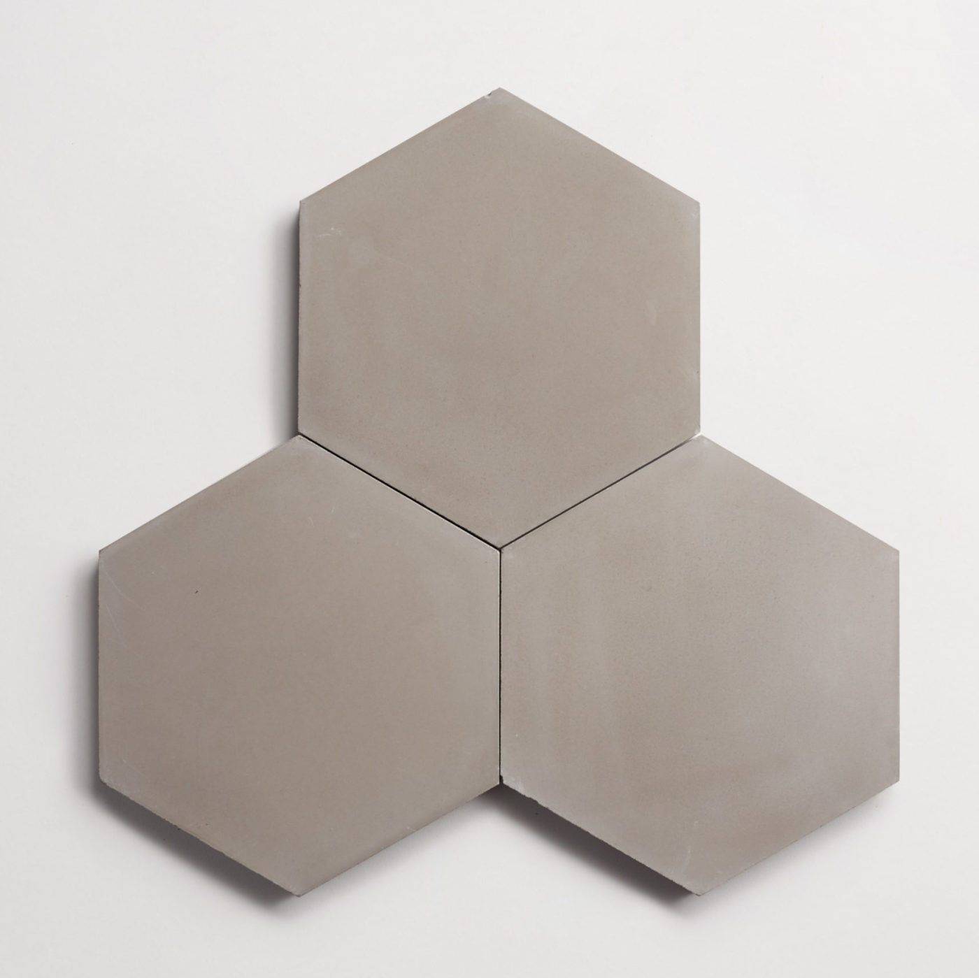 three grey hexagonal tiles on a white surface.