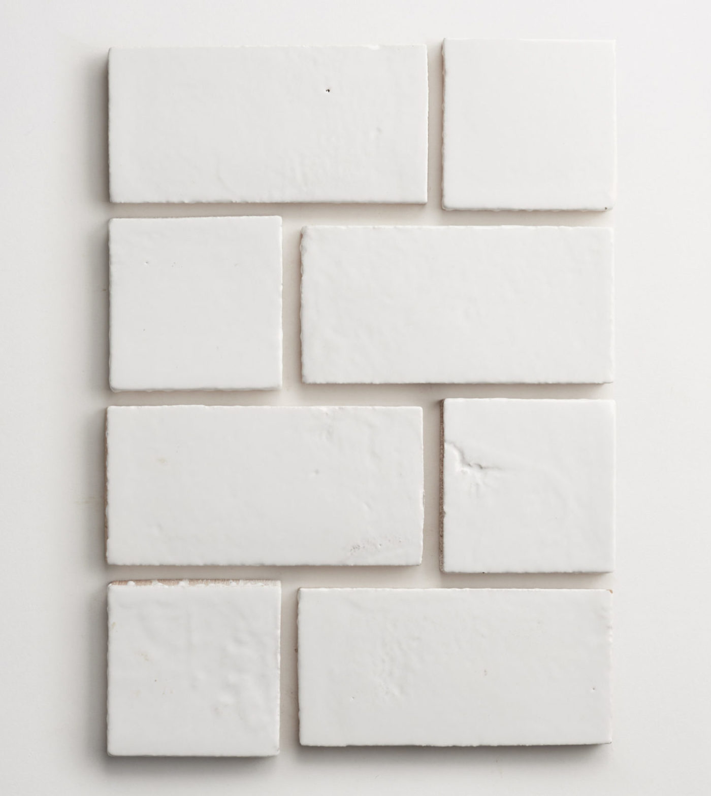 a group of square and rectangular white tiles arranged on a white surface.