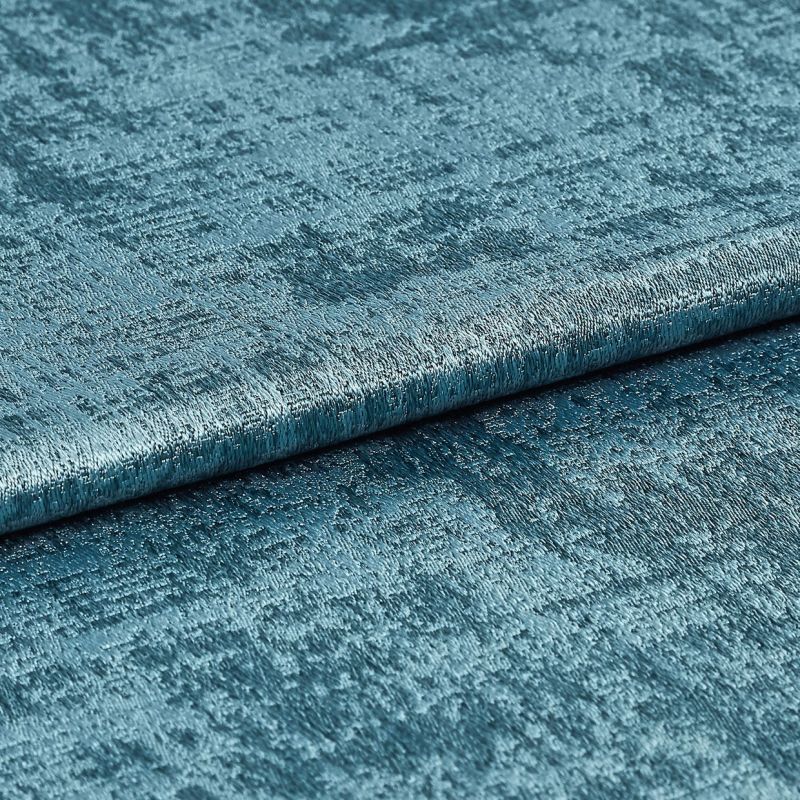 Teal crushed-velvet fabric sample, folded and shimmering, revealing irregular crushed texture; close-up studio view with soft directional lighting emphasizing the metallic sheen.