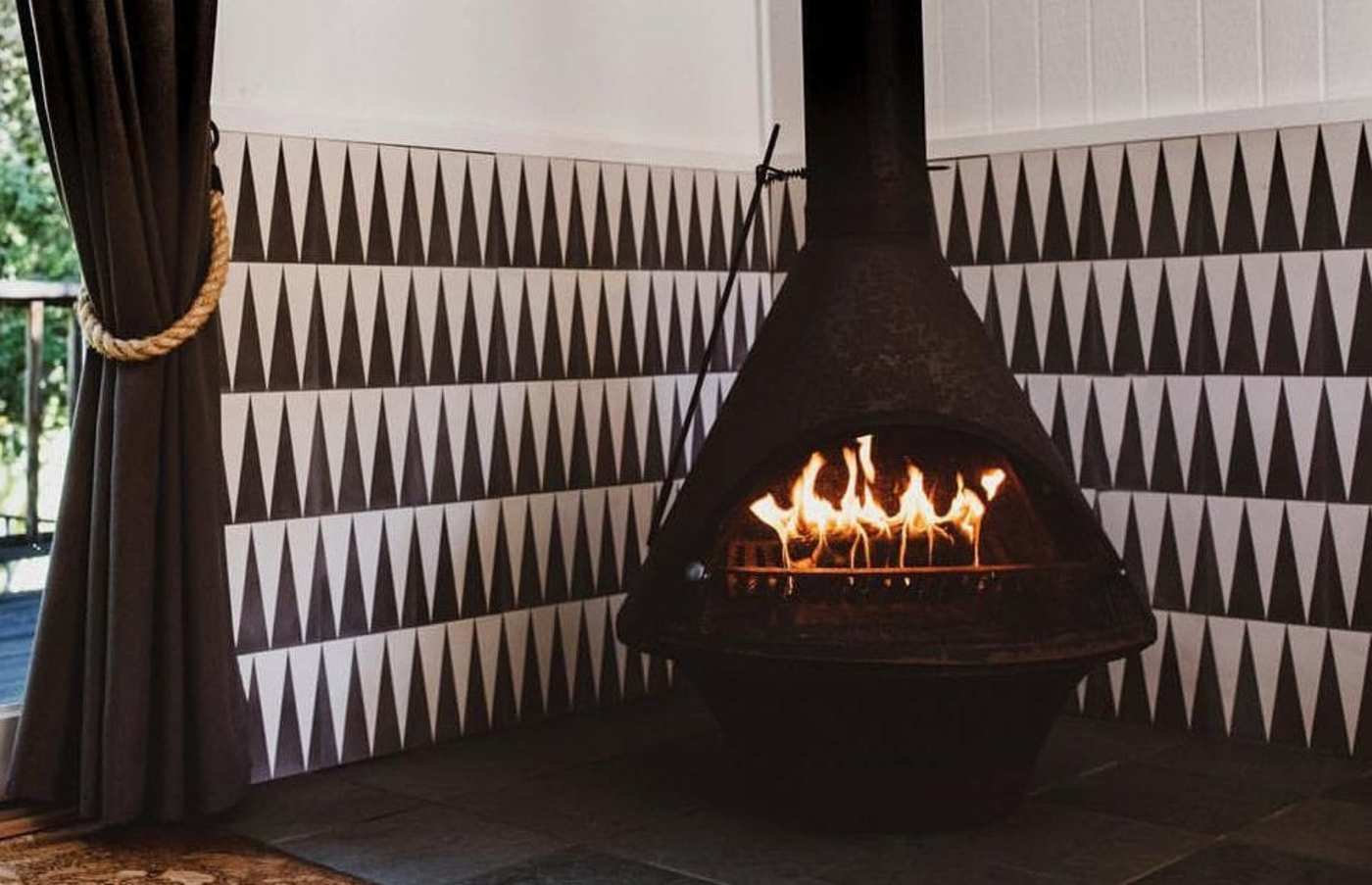 a fireplace surrounded by a black and white tile wall.