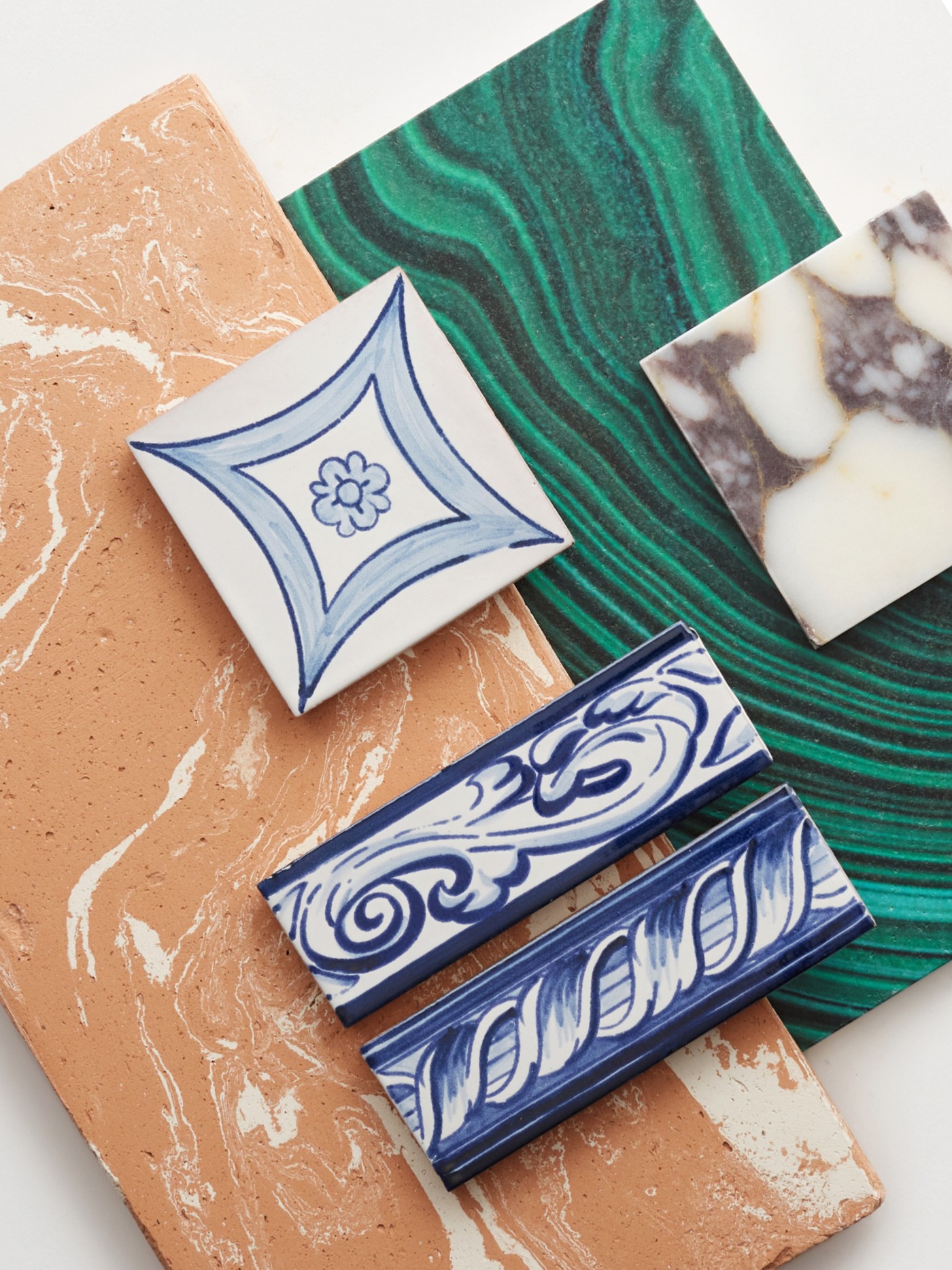 a collection of artisan tiles of various colors on a white surface.