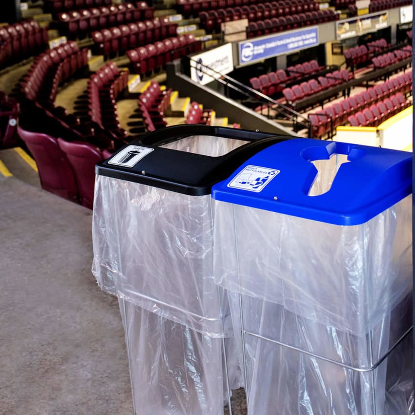 waste and mixed recycling event containers with colored lids and wire frame bodies at an arena