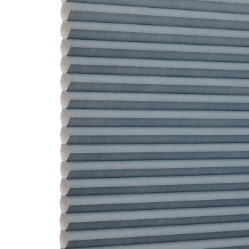 Blue-gray honeycomb (cellular) blind, fully lowered with horizontal pleats and visible hexagonal cells at the left edge; blocking light and insulating; shown close-up against a neutral, softly lit background.
