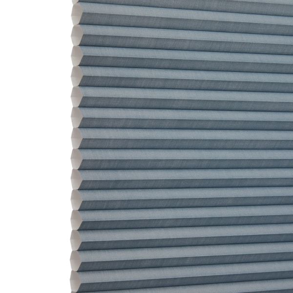 Blue-gray honeycomb (cellular) blind, fully lowered with horizontal pleats and visible hexagonal cells at the left edge; blocking light and insulating; shown close-up against a neutral, softly lit background.