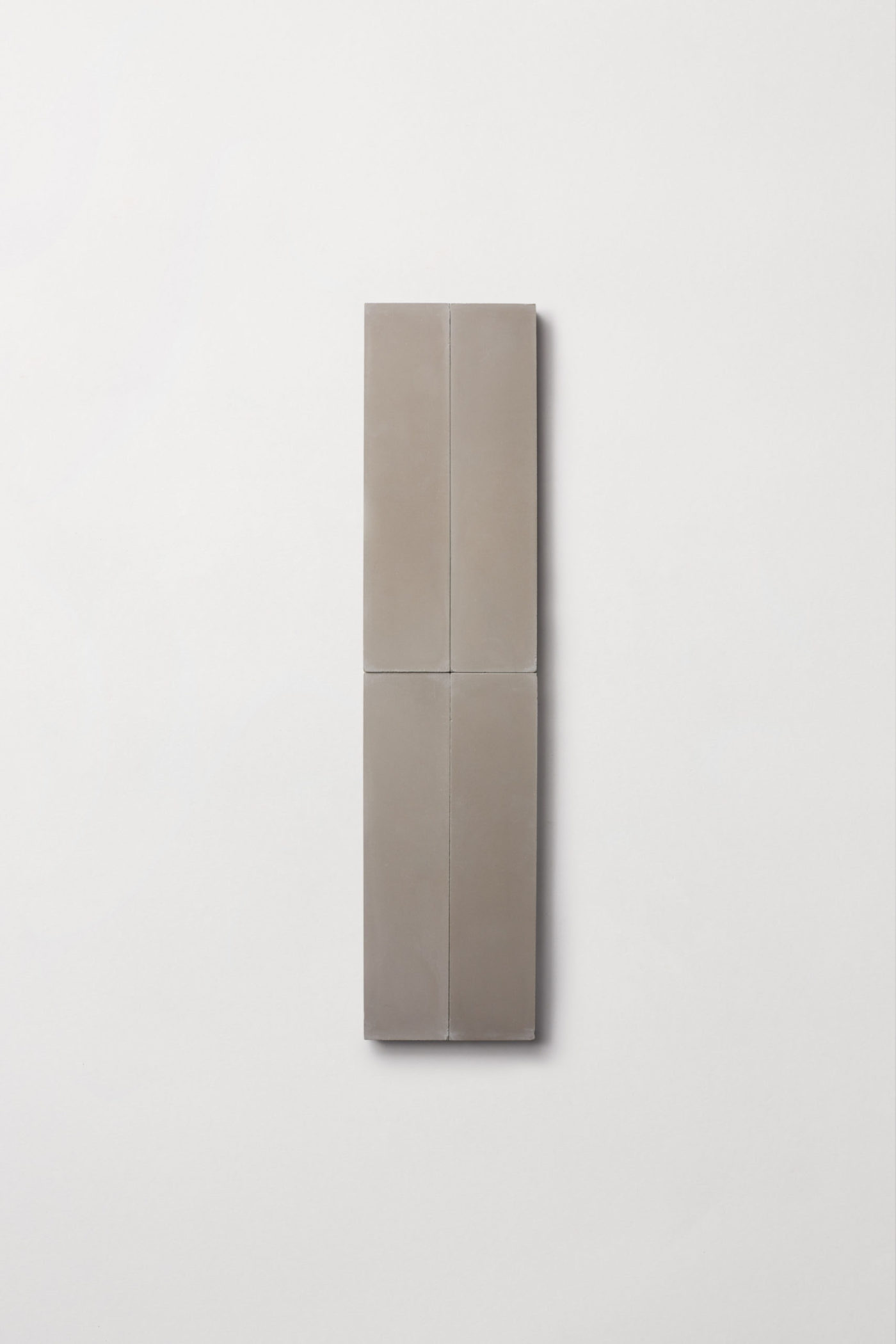 four grey rectangle tiles on a white surface.