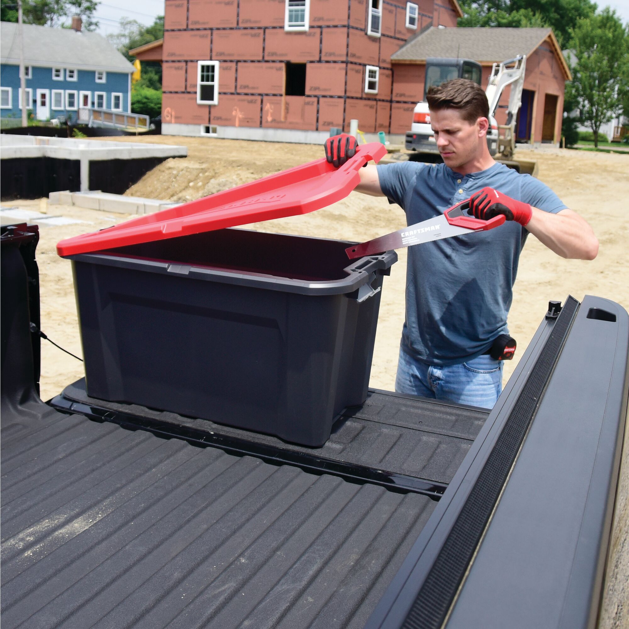 Right profile of 40 Gallon latching tote being used by a person to store tools.