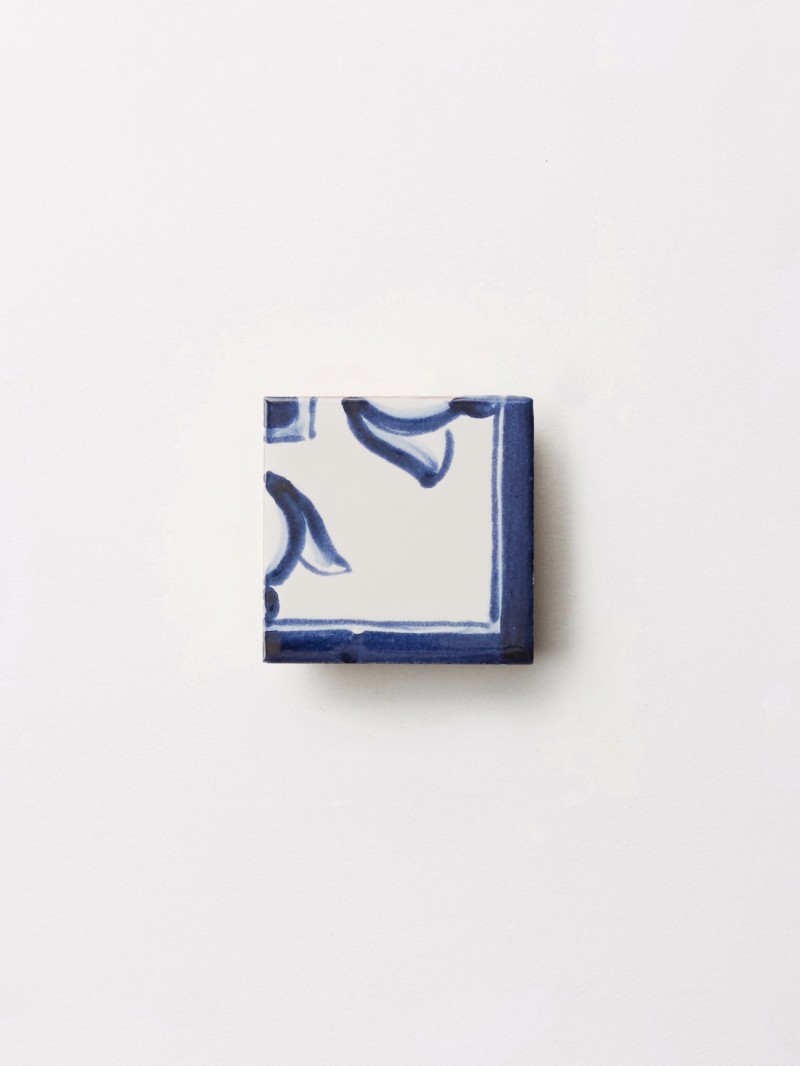 a blue and white tile on a white surface.