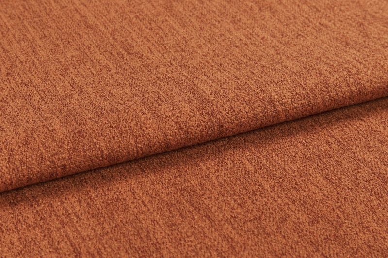Burnt-orange textured fabric (upholstery cloth) folded once, overlapping edge casting a soft shadow; close-up studio view highlighting its nubby weave and warm, evenly lit surface.