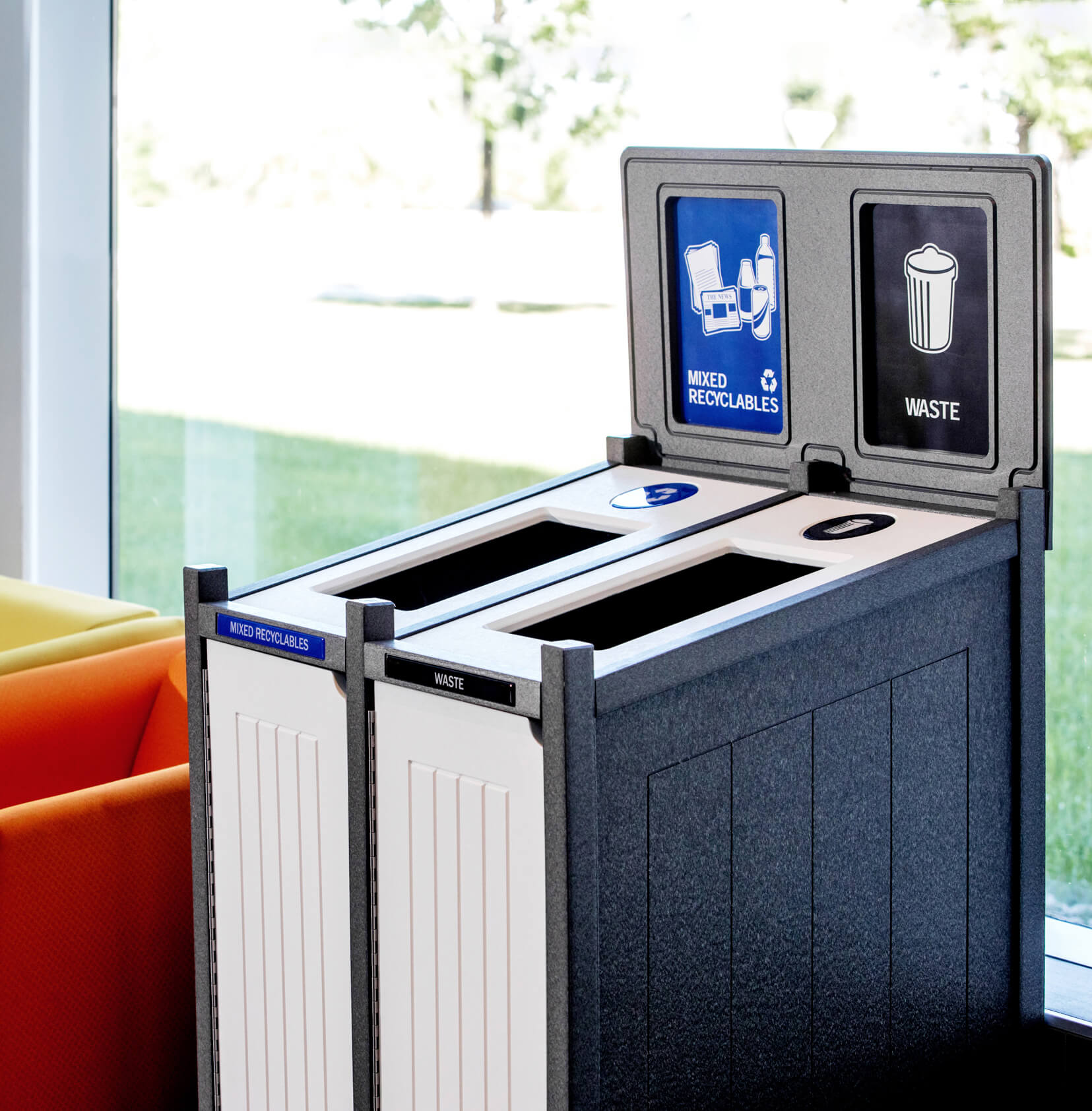 mixed recycling and trash container in an upscale office space beside a window