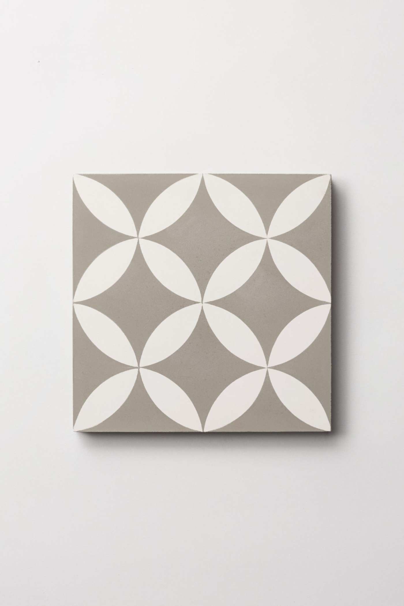 a grey and white tile with a flower design on it.