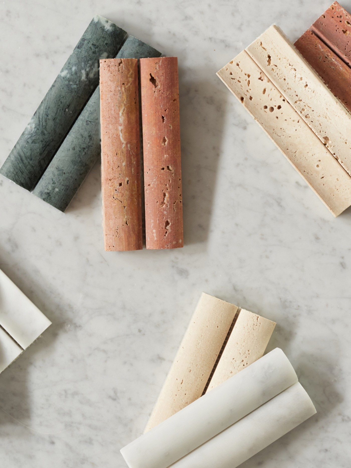 a group of different colored marble tiles on a marble table.