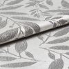 Silvery jacquard curtain fabric with raised leaf pattern, folded and overlapping to reveal texture, reflecting soft light; close-up studio view emphasizing woven sheen and botanical motif.