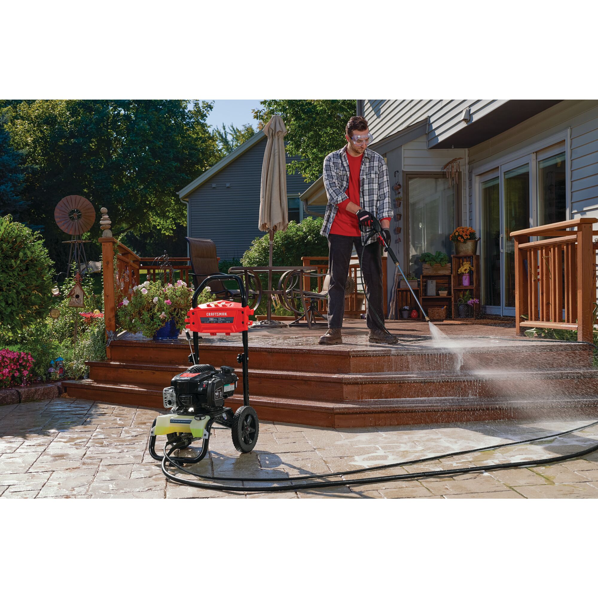 2800 Max P S I / 2.3 max G P M Pressure washer being used by a person to clean courtyard.