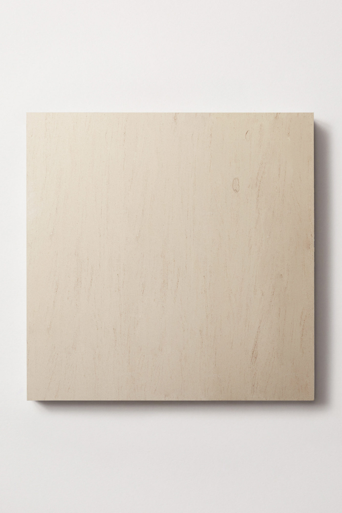 a square limestone tile in cream with darker veining and fine pores.