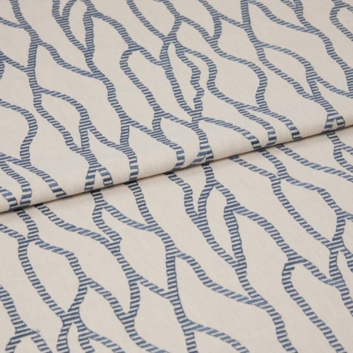 Beige fabric with repeating blue rope-like chain pattern, folded and layered across itself; close-up on a flat surface with soft, even lighting that emphasizes the woven texture.