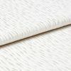 White wavy-ribbed fabric folded with an overlapping edge; fabric lies flat and layered. Close-up view under soft, diffuse light on a neutral surface, suggesting bedding or upholstery.