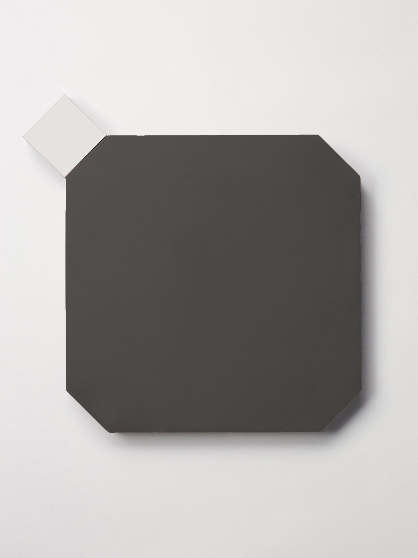 a black octagonal tile adjacent to a smaller white square tile.