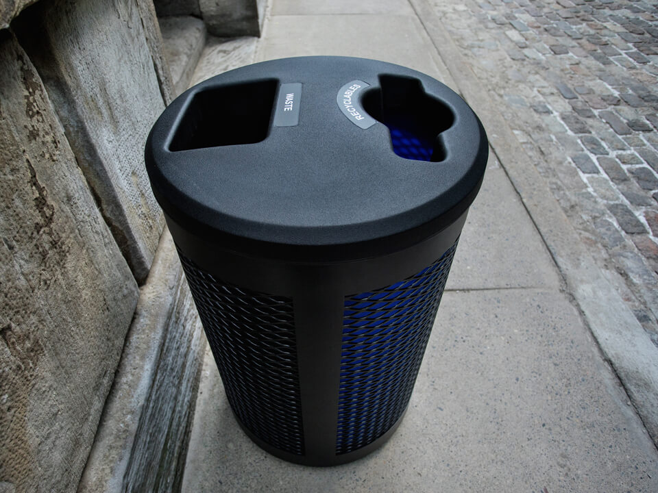 overhead view of a double stream waste and recycling container made from durable steel and LDPE plastic placed on a city sidewalk