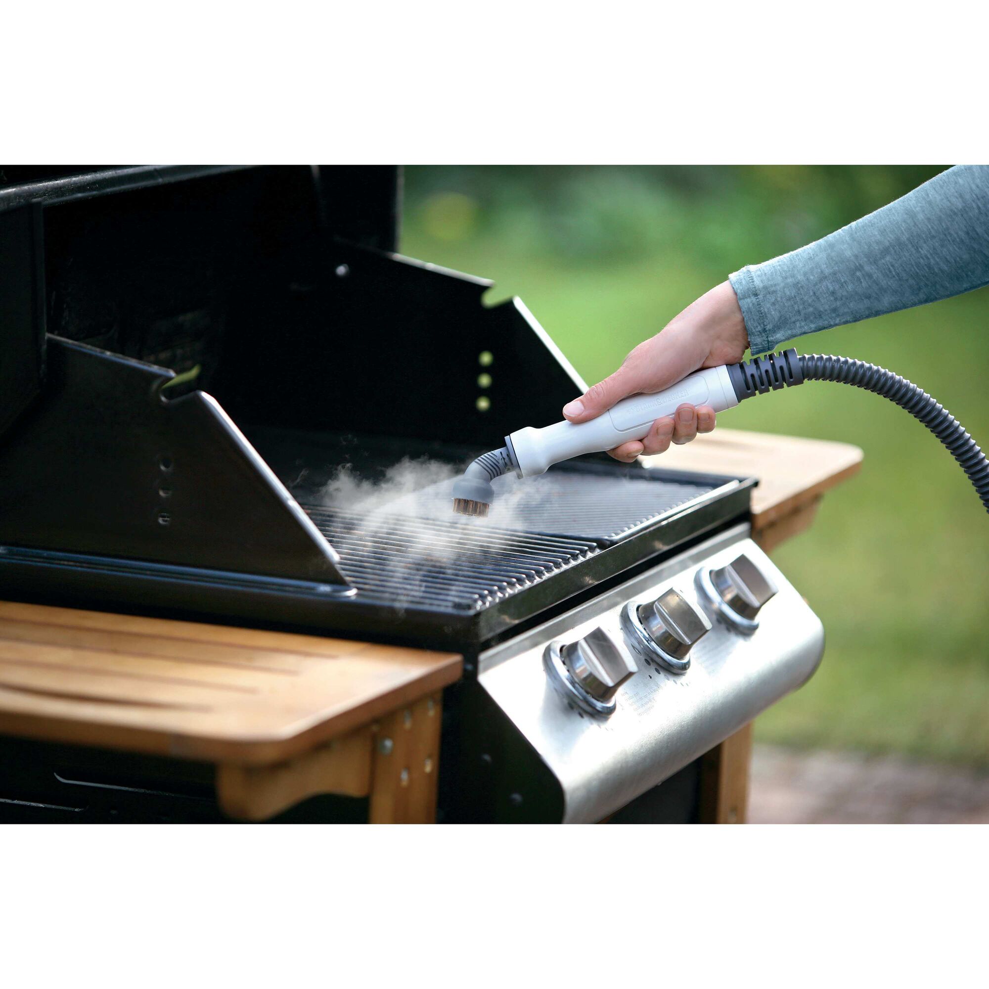 7 in 1 Steam Mop with steamglove handheld steamer being used to clean cooking grill.