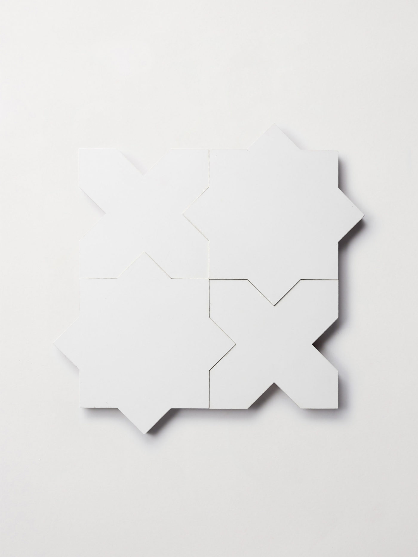 a set of white star and cross-shaped tiles on a white background.