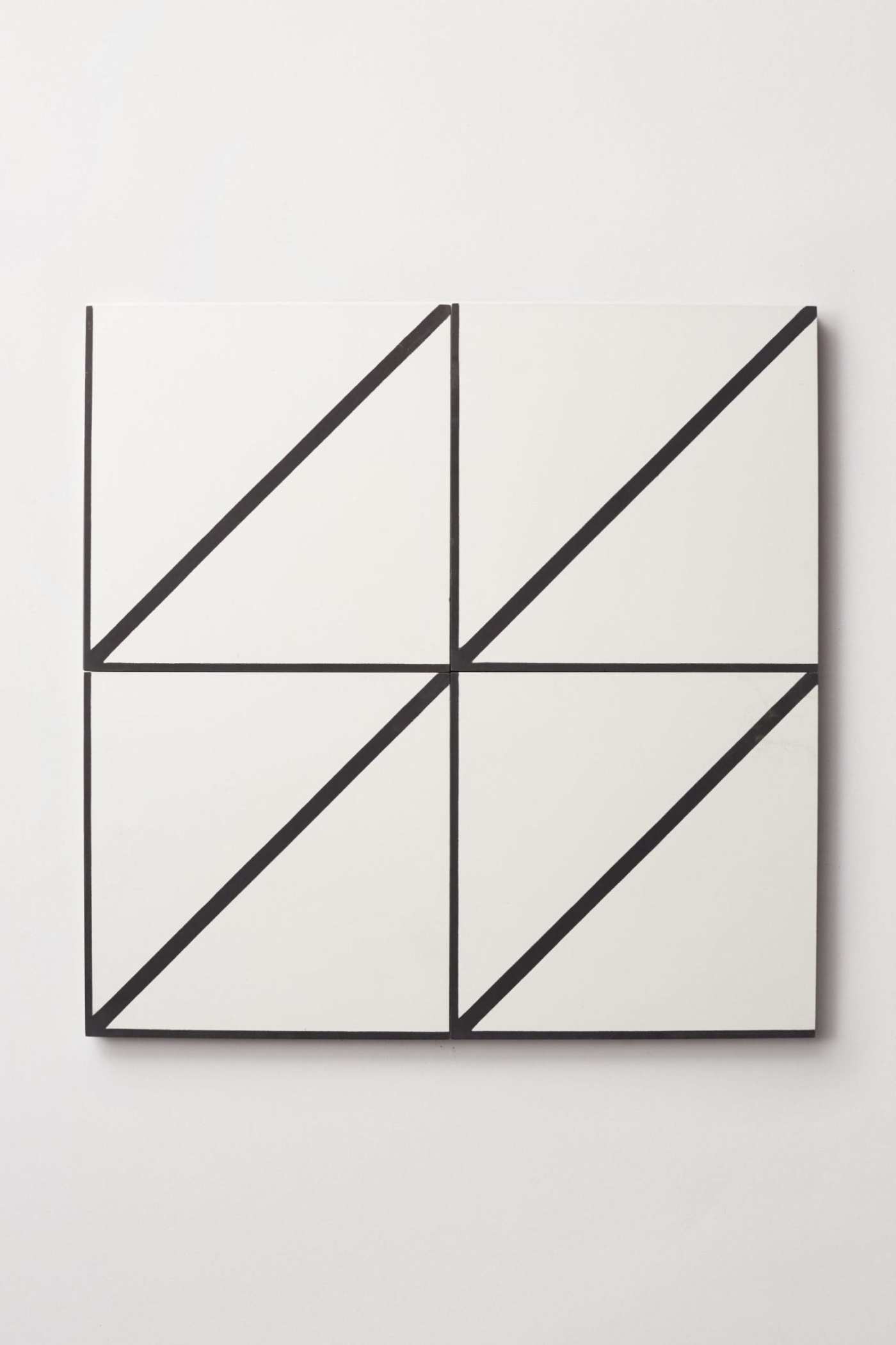 four white and black square tiles on a white wall.