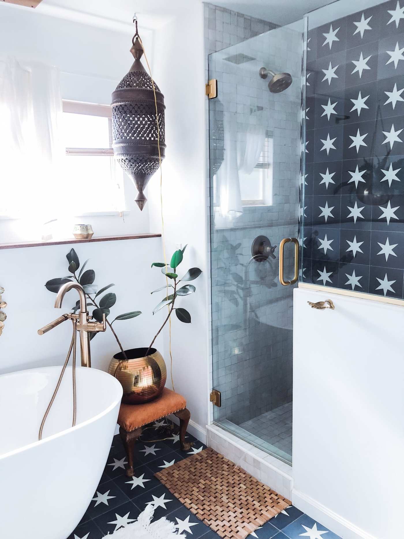 a bathroom with a black and white tiled floor and shower.