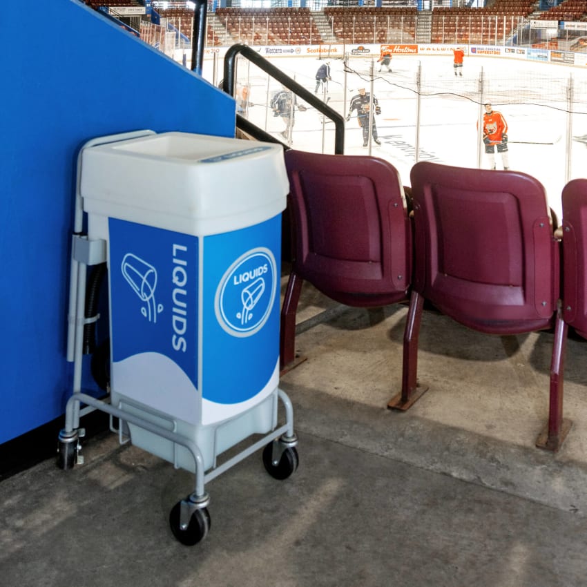 liquids collection container with a wheeled dolly in a hockey arena