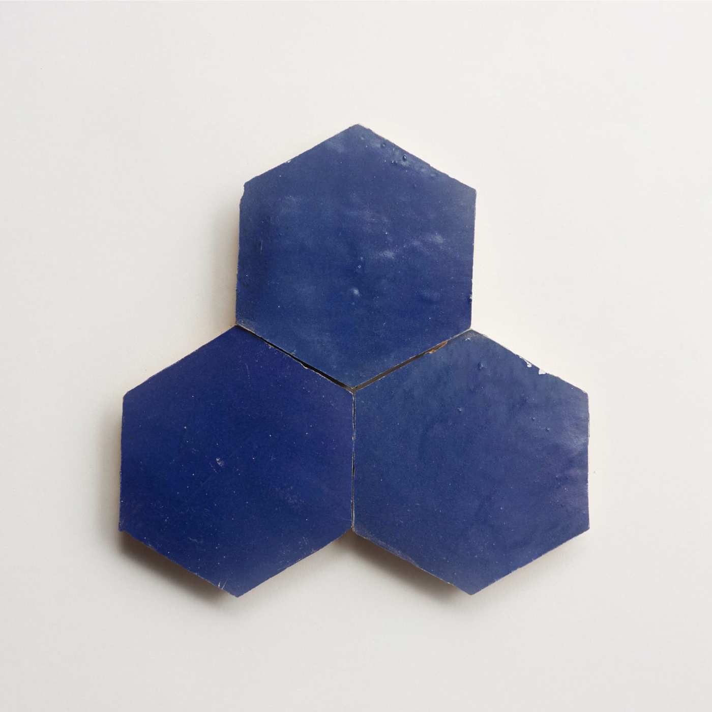 three blue hexagon tiles on a white surface.