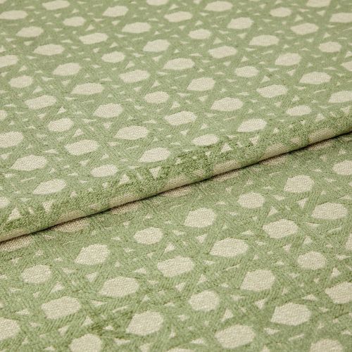 Green patterned woven fabric with raised geometric dots and lattice, folded over itself and showing textured pile; close-up studio view with soft, even lighting emphasizing the fibers.