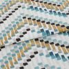 Fabric with abstract rectangular brushstroke pattern (teal, mustard, black, gray) â€” folded across the frame â€” close-up studio shot showing textured cotton/linen surface and even soft lighting.