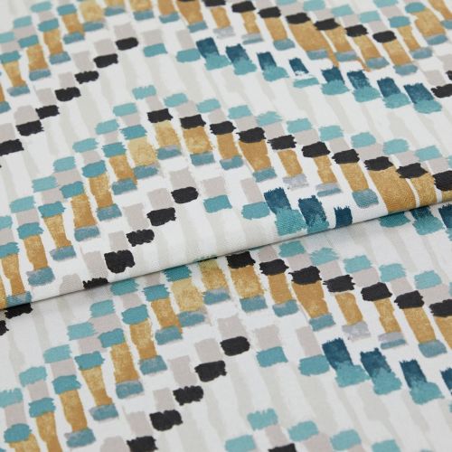 Fabric with abstract rectangular brushstroke pattern (teal, mustard, black, gray) — folded across the frame — close-up studio shot showing textured cotton/linen surface and even soft lighting.
