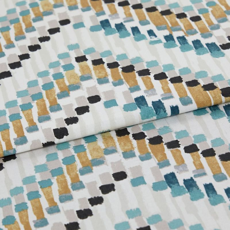 Fabric with abstract rectangular brushstroke pattern (teal, mustard, black, gray) â€” folded across the frame â€” close-up studio shot showing textured cotton/linen surface and even soft lighting.