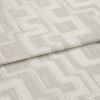 Beige woven fabric with raised cream geometric square pattern, folded in a horizontal overlap; close-up shot under soft neutral lighting, resembling an upholstery or drapery sample.