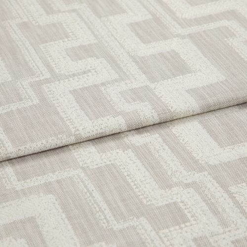 Beige woven fabric with raised cream geometric square pattern, folded in a horizontal overlap; close-up shot under soft neutral lighting, resembling an upholstery or drapery sample.