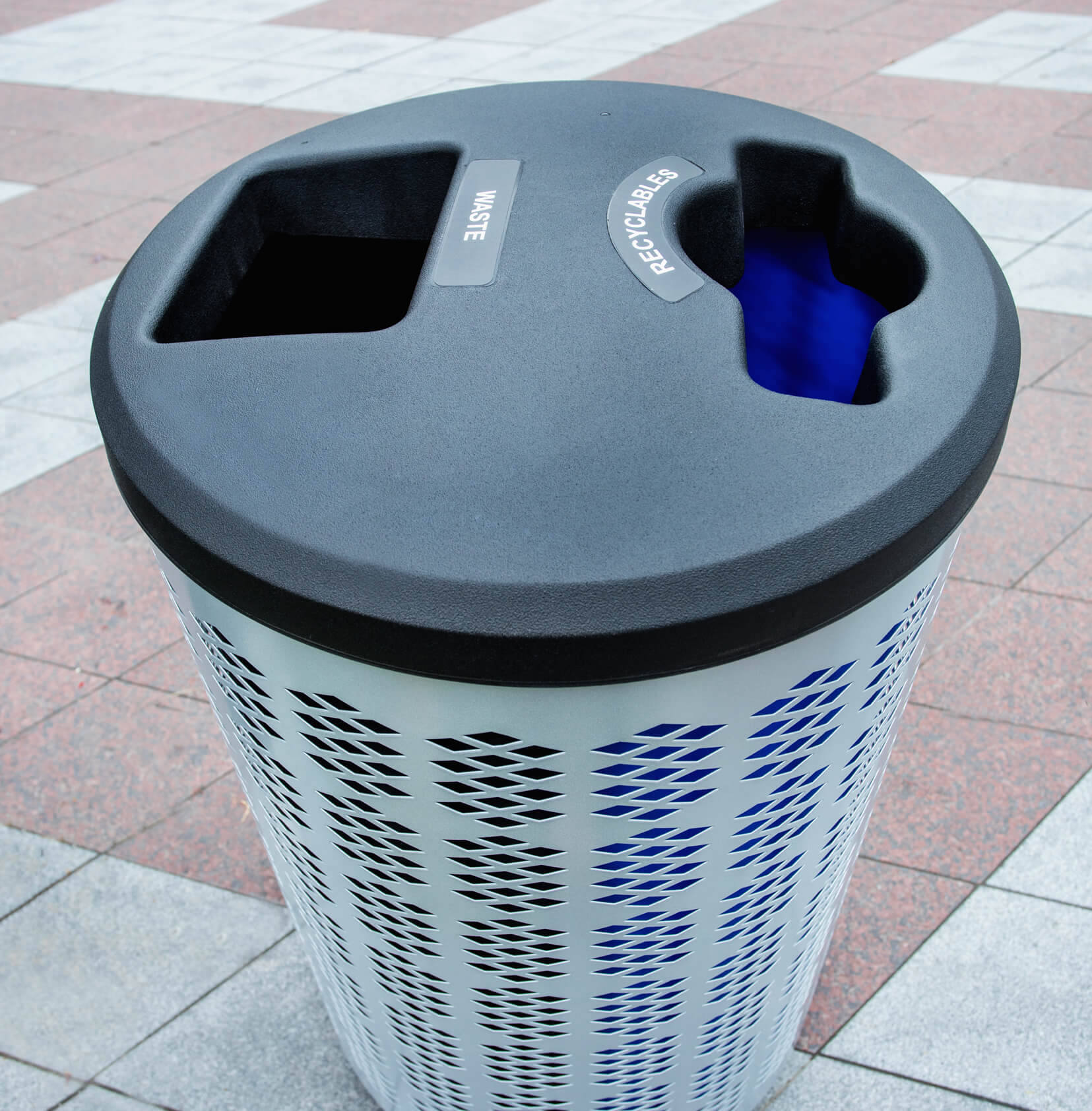 closeup of double waste and recyclables lid on powder coated steel body on a city sidewalk