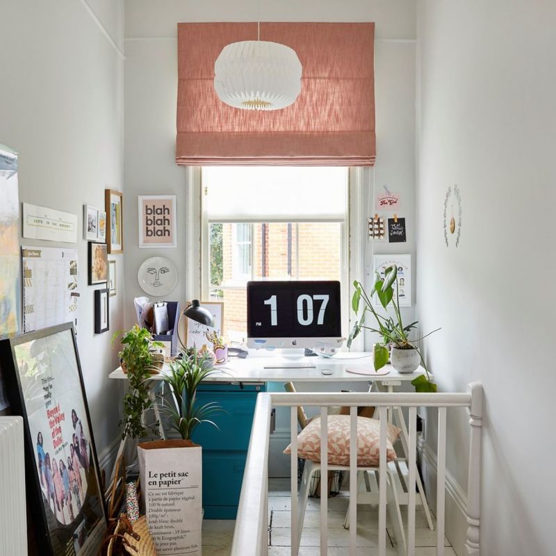 Pink fabric Roman blind, folded and lowered above a white roller blind, filtering soft daylight; compact bright home office with a desk, iMac clock, plants, pendant lamp, and wall art.

Transcription:
blah blah blah
1 07
PM
Le petit sac en papier