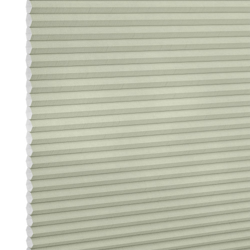 Cellular honeycomb blind, pale sage, fully lowered with visible hexagonal cells at left, blocking light; close-up product shot against a neutral white background with soft, even lighting.