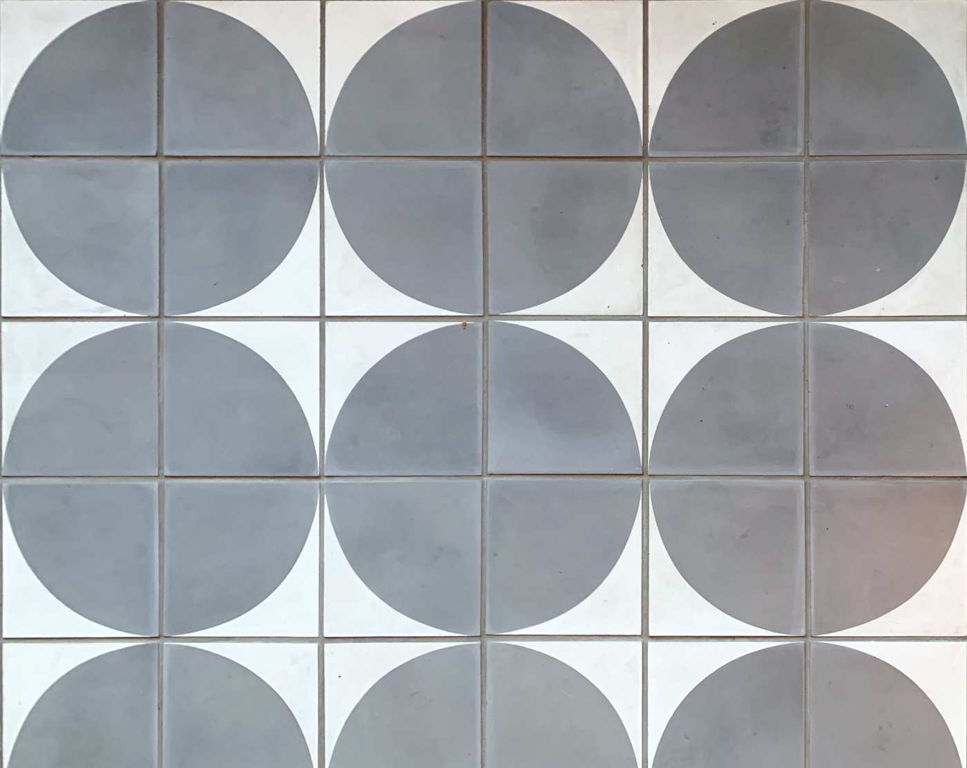 an arrangement of grey and white tiles forming a circular patterns.