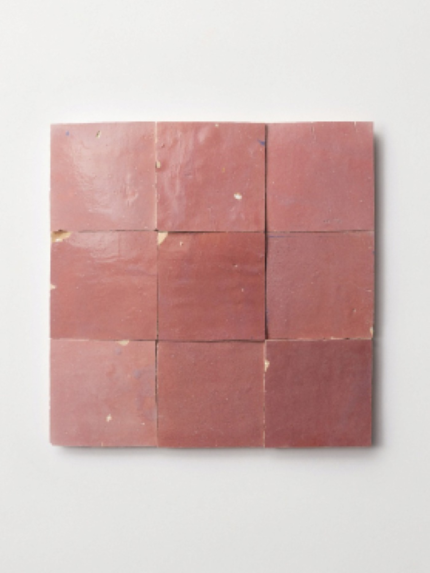 9 pieces of pink tile arranged on a white surface.