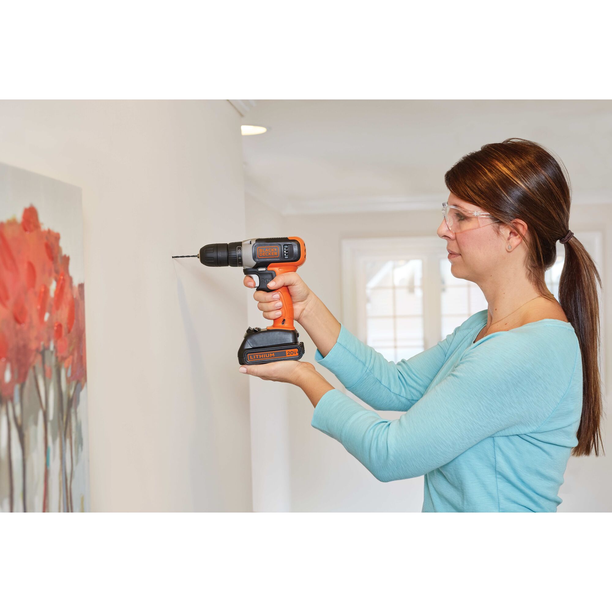 20 volt MAX drill with 63 piece hand tool and accessory home project kit being used by a person to drill a hole in wall.