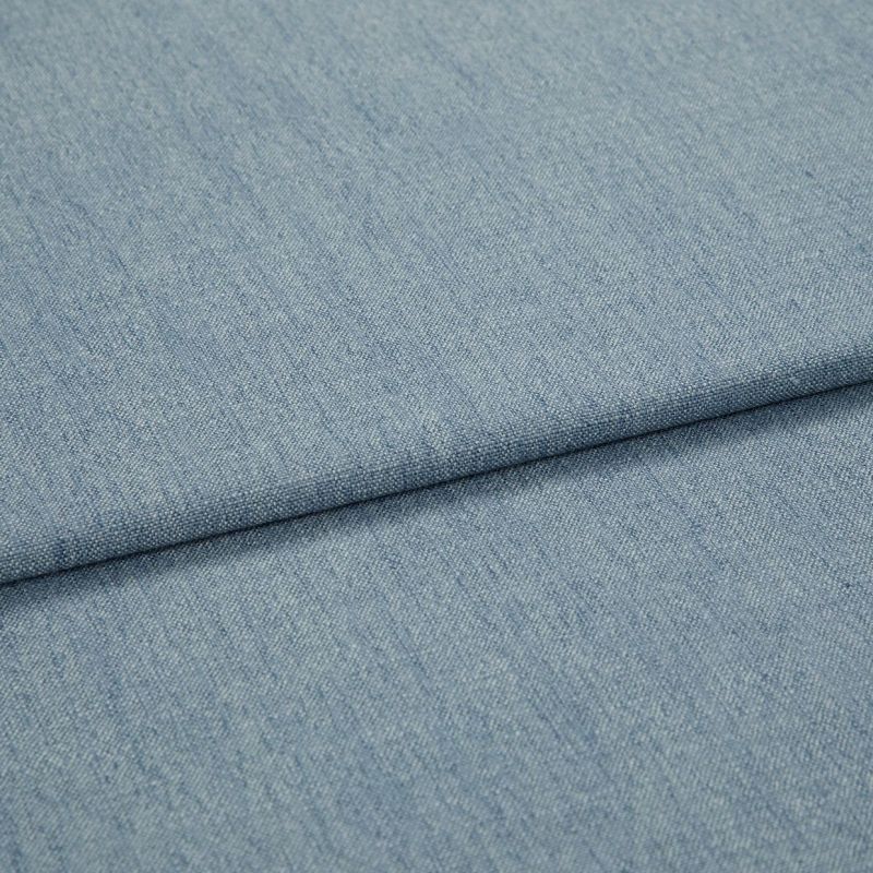 Light-blue woven denim-like fabric, folded diagonally with a shallow overlapping fold; surface shows fine weave and subtle striations, close-up view with soft, even lighting.