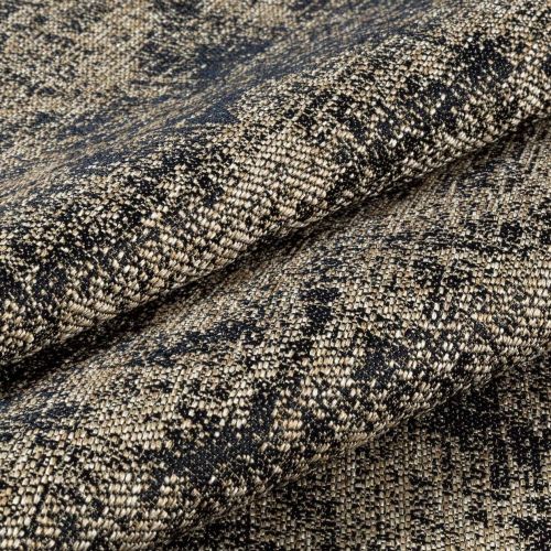 Heavy woven fabric with black-and-beige speckled pattern, shown folded and layered to display drape and texture; close-up macro view in neutral lighting suggesting upholstery or curtain material.
