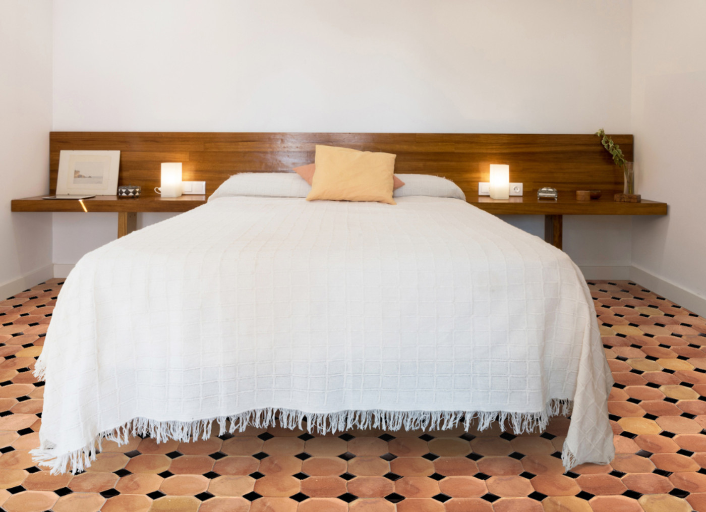 a bedroom with a white bed and a tiled floor.